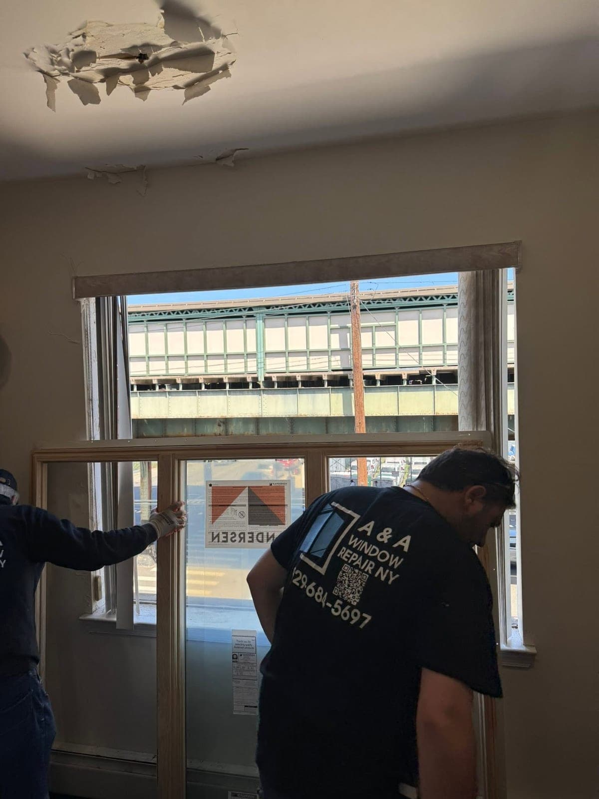 A&A Window Repair technician on site servicing a large storefront window